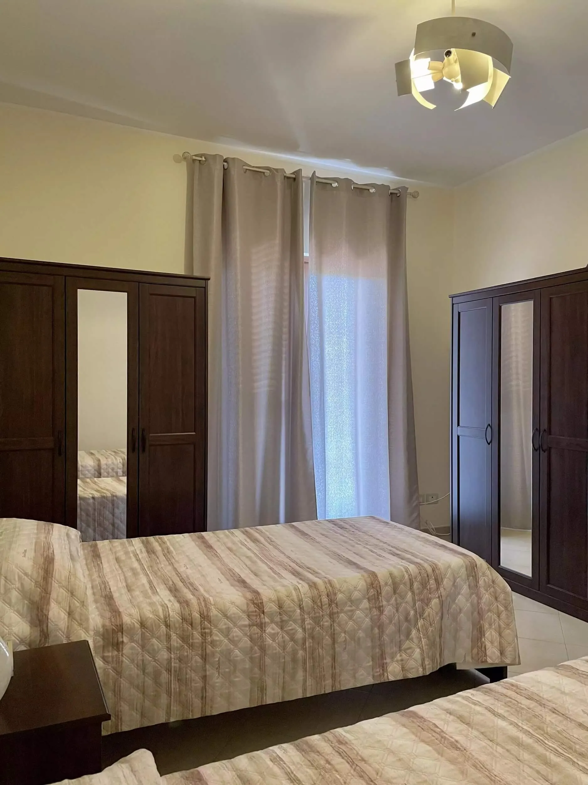 Camera con letto e due armadi in legno scuro